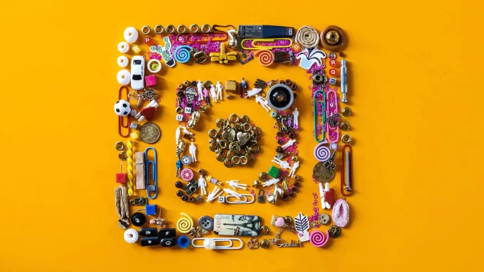Logo di Instagram creato con vari piccoli oggetti su sfondo giallo.